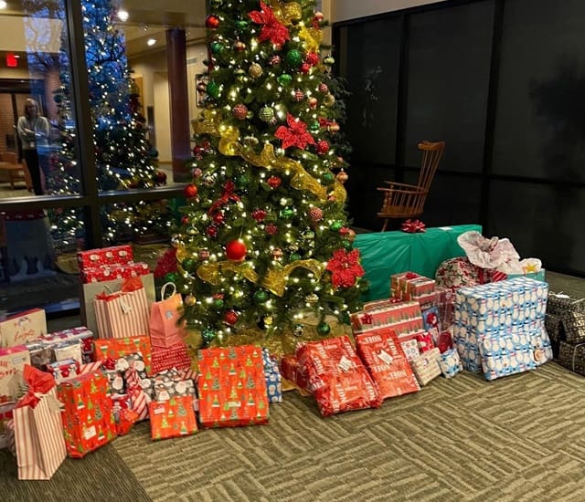 Social Responsibility - Colorful Wrapped Up Presents Lying Under a Decorated Christmas Tree Inside the McConkey Insurance Office