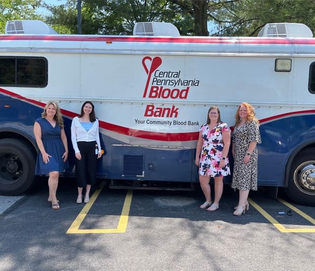 Social Responsibility - Four Female McConkey Employees Standing in Front of a Central Pennsylvania Blood Bank Truck