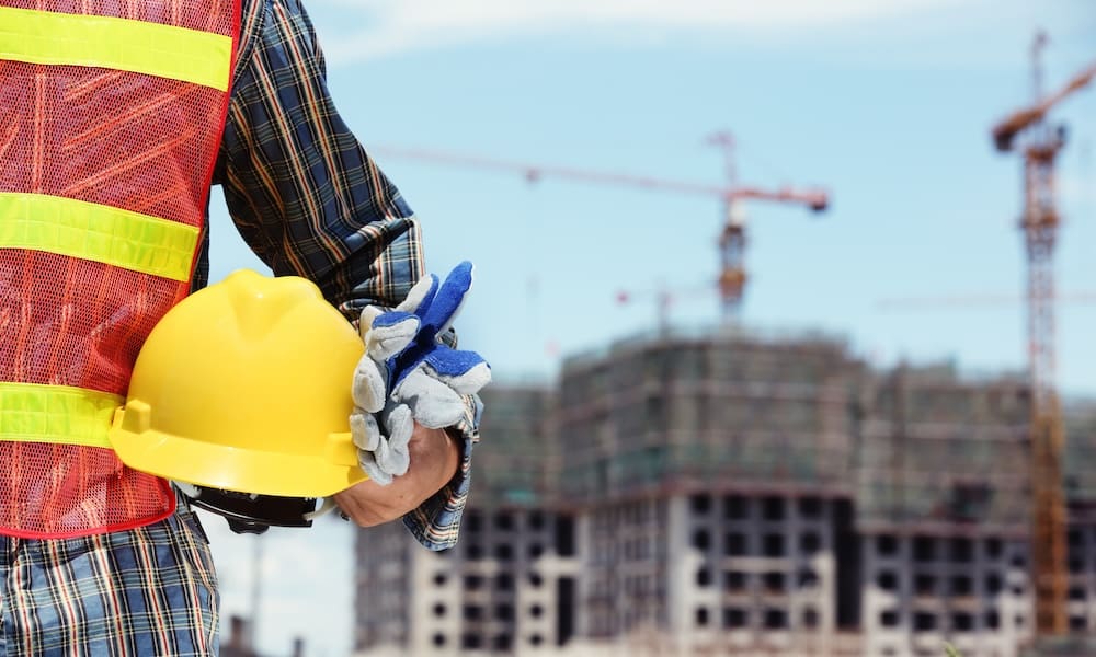 Personal Protective Equipment in Construction Proposed Rule Change - Construction Worker Wearing A Reflective Vest Holding a Hard Hat and Gloves