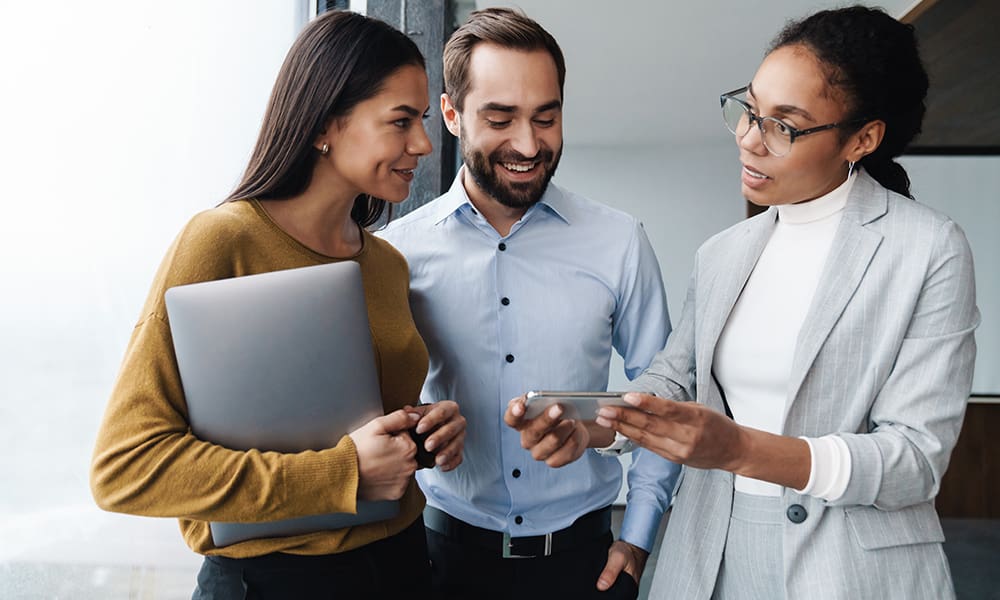 Blog - Professionals Talking While Looking at a Phone One is Holding