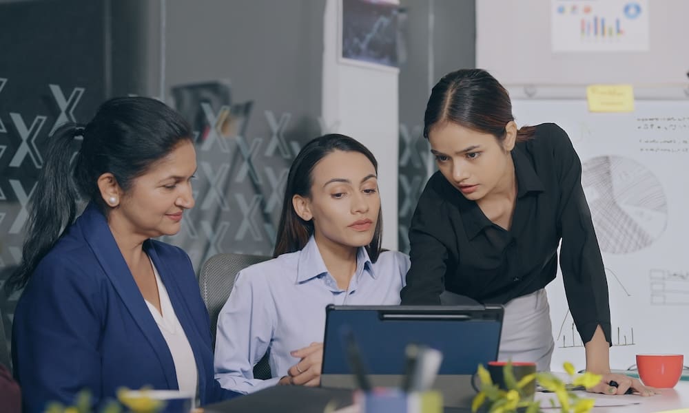 Does Joining a Group Captive Really Strengthen Your Business? - Group of women professional working together on a laptop