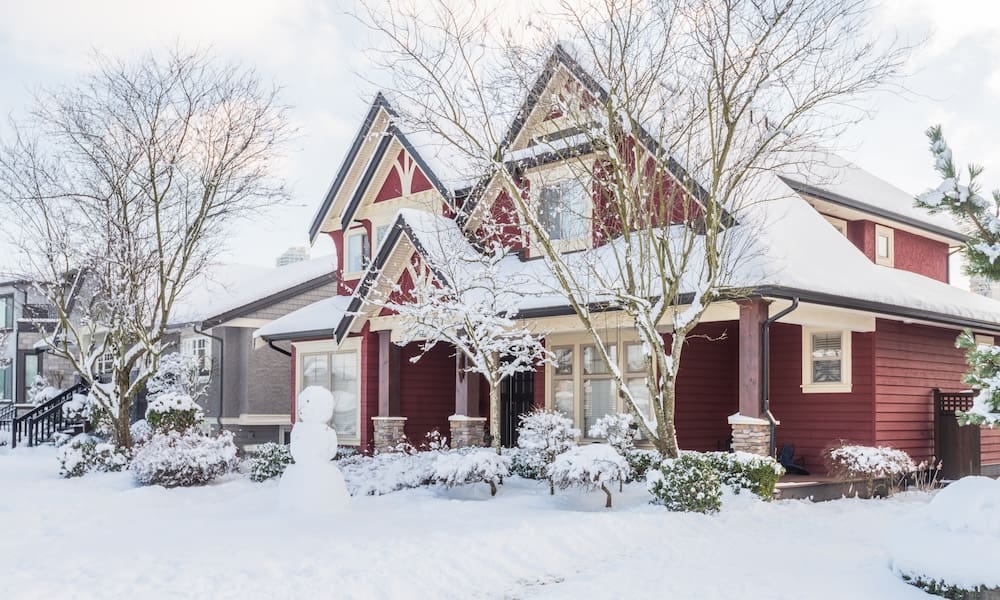 Red brick house covered in snow